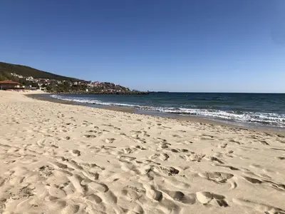 a beach with footprints in the sand and the ocean at Sveti Vlas Sky Dreams Apartment in Sveti Vlas