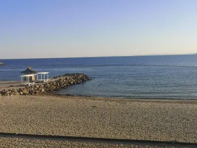 a beach with a gazebo and the water at Sveti Vlas Sky Dreams Apartment in Sveti Vlas