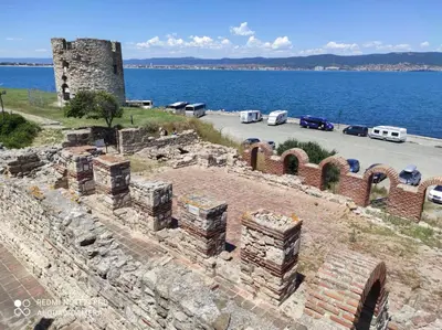 an old brick building next to a body of water at Sveti Vlas Sky Dreams Apartment in Sveti Vlas