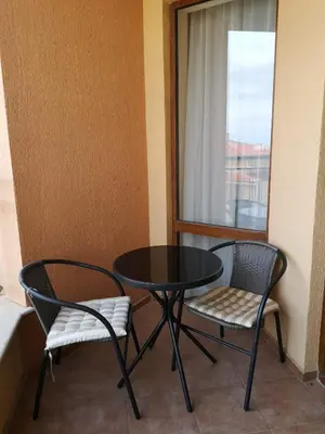 a table and two chairs in a room with a window at Sveti Vlas Sky Dreams Apartment in Sveti Vlas