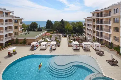 a pool at a hotel with a person in the water at Purple Rose Apartment Valencia Gardens in Nesebar