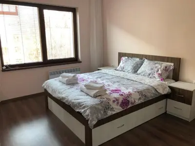 a bedroom with a bed with two towels on it at Purple Rose Apartment Valencia Gardens in Nesebar