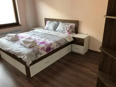a bedroom with a bed with two towels on it at Purple Rose Apartment Valencia Gardens in Nesebar