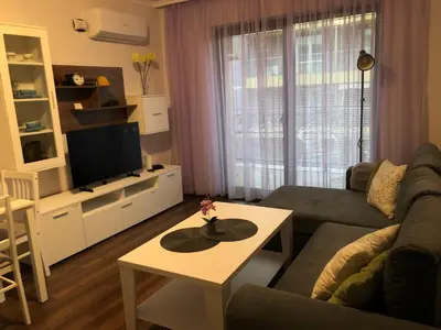 a living room with a couch and a table at Purple Rose Apartment Valencia Gardens in Nesebar