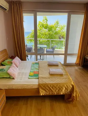 a bedroom with a bed with a view of the ocean at ALEX BEACH Apartello·com - Amazing apartments with sea view! in Sveti Vlas