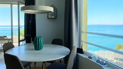 a table and chairs in a room with a view of the ocean at ALEX BEACH Apartello·com - Amazing apartments with sea view! in Sveti Vlas