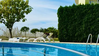 a swimming pool with white chairs next to a resort at ALEX BEACH Apartello·com - Amazing apartments with sea view! in Sveti Vlas