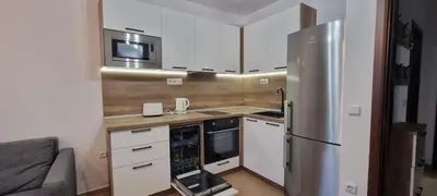 a kitchen with white cabinets and a stainless steel refrigerator at Deluxe Appartement in Cascadas Resort Sunny Beach in Sunny Beach