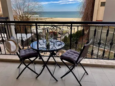 a table and two chairs on a balcony with the ocean at Luxurious 2 BR Appt at the Black Sea Coast in Sunny Beach
