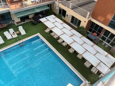 an overhead view of a pool with chairs and a hotel at Apartament Milenium in Pomorie