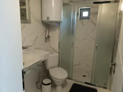 a bathroom with a shower and a toilet and a sink at Apartament Milenium in Pomorie