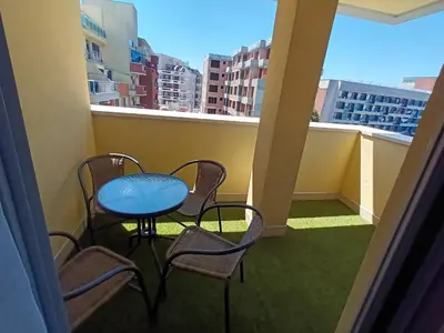 a balcony with a table and chairs and a window at Apartament Milenium in Pomorie