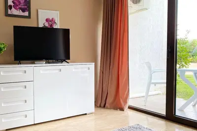 a living room with a television on a white dresser at APARTELLO⊛com DIAMOND - private apartments near Marina Dinevi in Sveti Vlas in Sveti Vlas