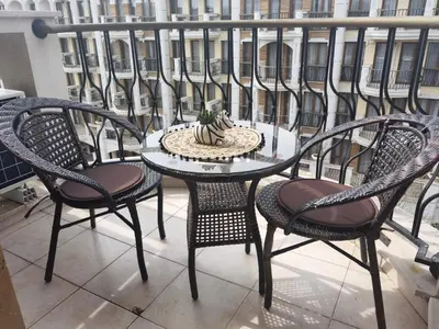 a table and chairs on a balcony with a cake on it at Harmony Suitеs apartment in Sunny Beach