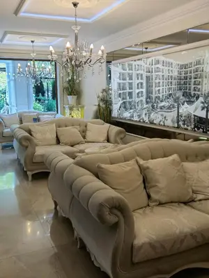 a large living room with couches and a chandelier at Harmony Suitеs apartment in Sunny Beach