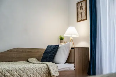 a bedroom with a bed with a pillow and a lamp at Lovely Art apartment - Victory in Varna City