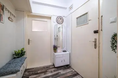 a hallway with a door and a clock on the wall at Lovely Art apartment - Victory in Varna City