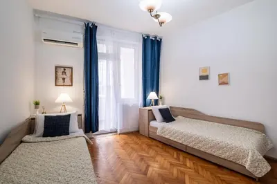 a bedroom with two beds and a large window at Lovely Art apartment - Victory in Varna City