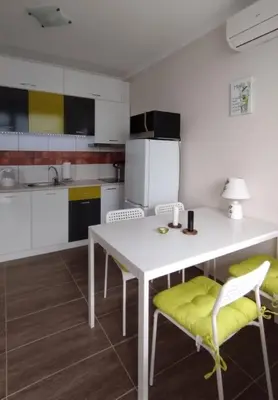 a kitchen with a white table and chairs at Apartments SunWave Saint Vlas in Sveti Vlas