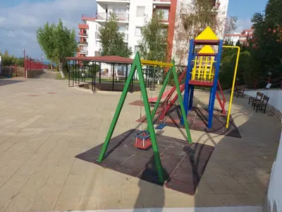a playground with a colorful swing set in a park at Apartment in Sveti Vlas in Sveti Vlas