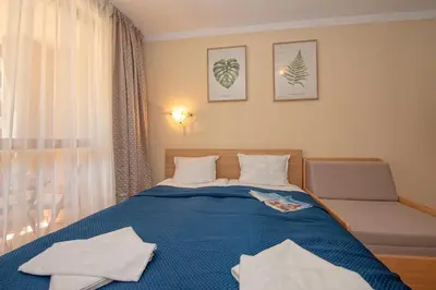 a bedroom with a blue bed and a chair at Cascadas Holiday Apartments in Sunny Beach