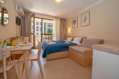 a bedroom with a bed and a dining room at Cascadas Holiday Apartments in Sunny Beach