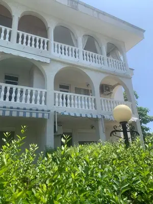 a large white building with a balcony and a street light at Fantastic Apartment in Sveti Vlas in Sveti Vlas