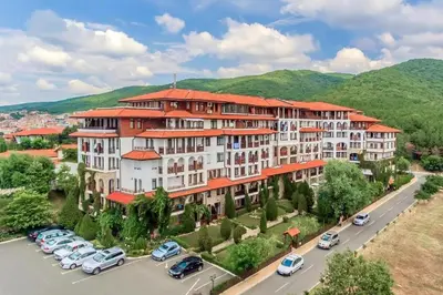 a large building with cars parked in a parking lot at Two room apartment in Etara 3, Sveti Vlas in Sveti Vlas