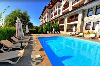 a pool in front of a hotel with chairs and umbrellas at Two room apartment in Etara 3, Sveti Vlas in Sveti Vlas
