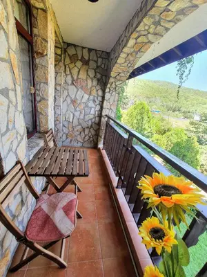 a balcony with two benches and a window with sunflowers at Two room apartment in Etara 3, Sveti Vlas in Sveti Vlas