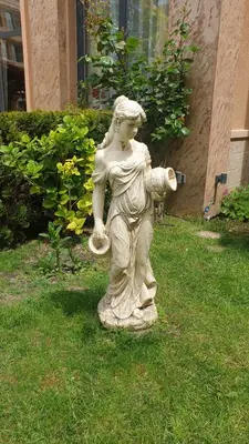 a statue of a woman sitting in the grass at Апартамент под наем С208 в Афродита Гарденс in Sunny Beach