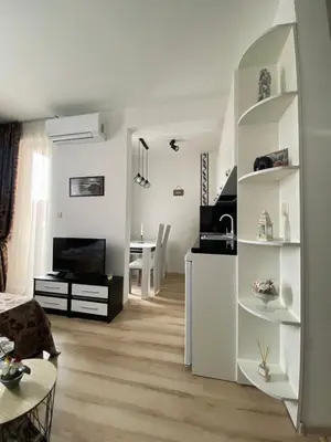 a white living room with a kitchen and a dining room at Апартамент под наем С208 в Афродита Гарденс in Sunny Beach