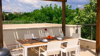 a wooden table and chairs on a balcony with a table at Byala Cliff Sea View Penthouse in Byala