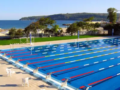 a large swimming pool with blue and red lanes at Апартамент Далия - Apartment Dalia in Varna City