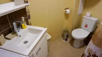 a bathroom with a white sink and a toilet at Апартамент Далия - Apartment Dalia in Varna City