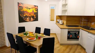 a kitchen with a wooden table and chairs in a kitchen at Апартамент Далия - Apartment Dalia in Varna City