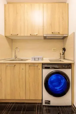 a washing machine with a blue lid in a kitchen at Стаи за гости ПИРОТСКА 39 in Burgas City