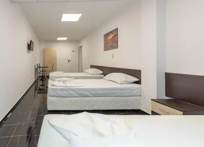 two beds in a room with white walls at Стаи за гости ПИРОТСКА 39 in Burgas City
