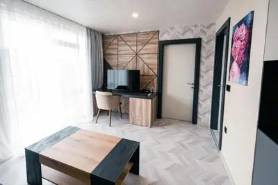 a living room with a table and a television at хотел ADDRESS in Ravda
