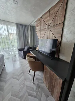 a living room with a television on a wall at хотел ADDRESS in Ravda
