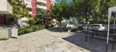 a park with benches and trees in front of a building at Apartmány Rose Residence Nesebar in Sunny Beach