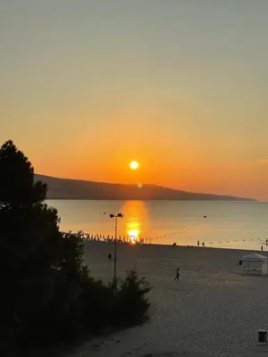 a sunset on a beach with people on the beach at Apart hotel Gallery A in Sunny Beach