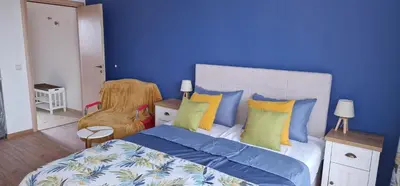 a blue bedroom with a large bed with colorful pillows at Studio Fresh in Sozopol