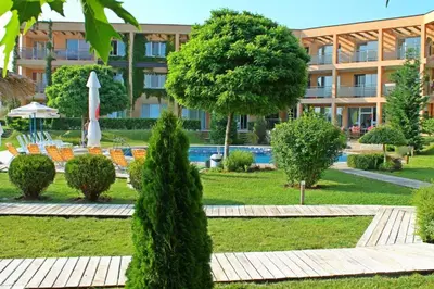 a park with trees and chairs and a building at Studio Fresh in Sozopol