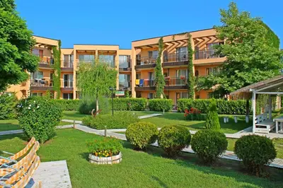 an apartment building with a garden in front of it at Studio Fresh in Sozopol