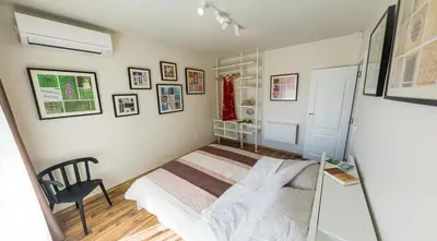 a small bedroom with a bed and a chair at Sea grape wine flat in old center in Varna City