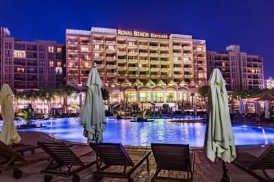 a hotel with chairs and umbrellas in front of a pool at ROYAL BEACH & APARTAMENT in Sunny Beach