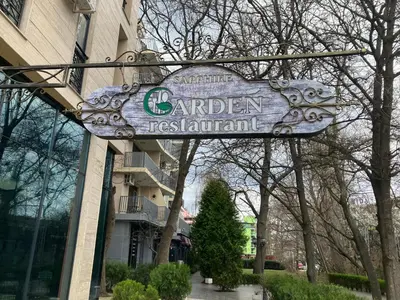 a sign for a garden restaurant in front of a building at Joy Apartment Sunny Beach in Sunny Beach