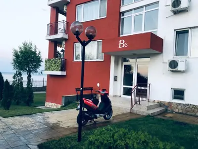 a motor scooter parked in front of a building at Beautiful apartment right by the sea, Sveti Vlas in Sveti Vlas