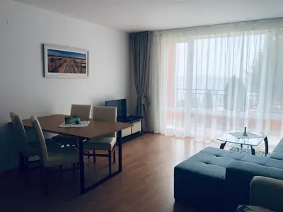 a living room with a dining room table and a couch at Beautiful apartment right by the sea, Sveti Vlas in Sveti Vlas